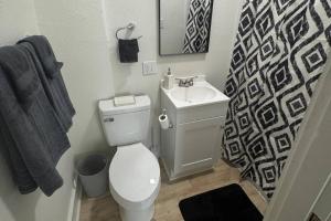 a bathroom with a white toilet and a sink at Fully Furnished Monthly Stay or Weekend Getaway in Hot Springs