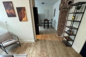 a living room with a chair and a brick wall at Fully Furnished Monthly Stay or Weekend Getaway in Hot Springs