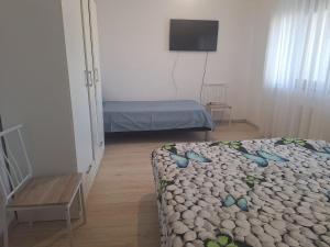 a small room with a bed and a television at Apartament Sos Alexandriei Bragadiru in Bragadiru