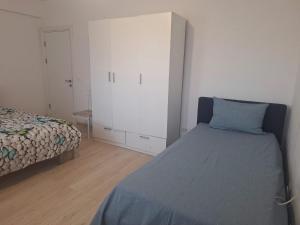 a bedroom with a bed and a white cabinet at Apartament Sos Alexandriei Bragadiru in Bragadiru