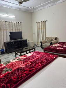 ein Wohnzimmer mit zwei Betten und einem Flachbildfernseher in der Unterkunft Awari guest house in Hyderabad