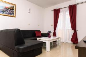 ein Wohnzimmer mit einer schwarzen Couch und einem Tisch in der Unterkunft Ganzes Ferienhaus in Pisak mit Privatem Pool in Pisak