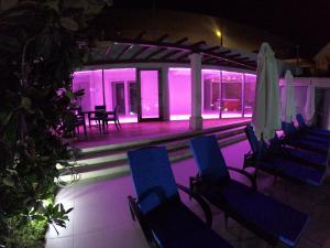 eine Gruppe von Stühlen und Sonnenschirmen in einem Gebäude in der Nacht in der Unterkunft Große Ferienwohnung in Splitska mit gemeinsamem Pool, Garten und Terrasse in Splitska