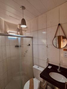 a bathroom with a shower and a toilet and a sink at Pousada Praia Dos Encantos in Japaratinga +16 photos