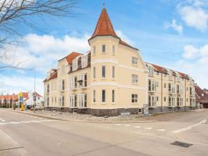 a large white building with a tower on a street at 4 star holiday home in Hejls in Hejlsminde