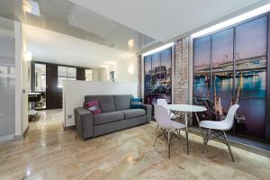 sala de estar con sofá, mesa y sillas en Suites Garden Loft Dalí, en Las Palmas de Gran Canaria