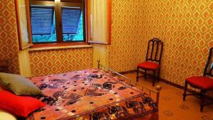 a bedroom with a bed and two chairs and a window at Caregli Countryhouse in Borzonasca