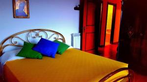 a bed with green and blue pillows on it at Caregli Countryhouse in Borzonasca