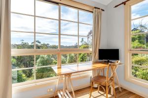 温特沃斯瀑布Graylyn House Wentworth Falls Blue Mountains的窗户客房内的一张带电脑的桌子