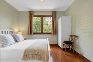 温特沃斯瀑布Graylyn House Wentworth Falls Blue Mountains的卧室里有一张白色的大床和一扇窗户