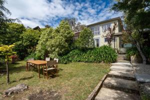 温特沃斯瀑布Graylyn House Wentworth Falls Blue Mountains的院子里带桌椅的房子