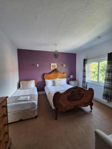 a bedroom with two beds and purple walls at The Stokesay Inn in Craven Arms +18 photos