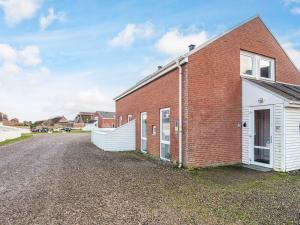 a red brick building with a white garage at 6 person holiday home in Rømø-By Traum in Sønderby