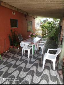 eine Terrasse mit einem Tisch und Stühlen auf einer Terrasse in der Unterkunft De Sol a Sol in Barra de Valizas
