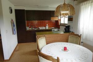 una cocina con una mesa con una vela roja. en Akalei, en Aeschi