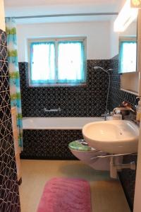 Un baño con lavabo, inodoro y ventana. en Akalei, en Aeschi