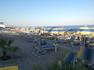 Un montón de sillas y sombrillas en una playa en Eutimo, en Locri 2 fotos más