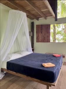 a bedroom with a bed with a mosquito net at Punta Brava in Nuquí