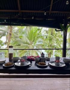 a table with bowls and plates of food on it at Punta Brava in Nuquí
