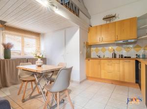 eine Küche und ein Esszimmer mit Tisch und Stühlen in der Unterkunft Jolie petite maison climatisée parking privé in Gujan-Mestras + 17 Fotos