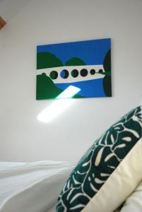 a painting hanging on a wall above a bed at Charmante maison 2 chambres et parking privé in Fleurey-sur-Ouche +11 photos