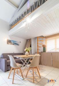 ein Wohnzimmer mit Tisch und Stühlen in der Unterkunft Jolie petite maison climatisée parking privé in Gujan-Mestras