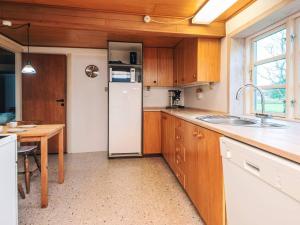a kitchen with a white refrigerator and a table at 5 person holiday home in Rømø in Toftum