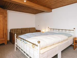 a bedroom with a white bed with a wooden ceiling at 5 person holiday home in Rømø in Toftum