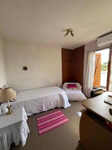 ein Schlafzimmer mit zwei Betten und einem Tisch mit Lampe in der Unterkunft vainilla y lavanda in Ciudad de la Costa