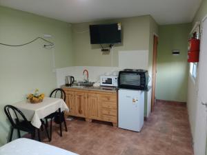 a small kitchen with a table and a microwave at La Delia monoambiente in Gualeguaychú