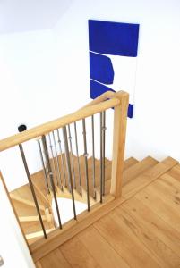 a wooden stair railing with a flag on it at Charmante maison 2 chambres et parking privé in Fleurey-sur-Ouche