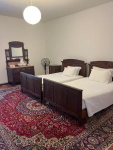 una camera con 2 letti, uno specchio e un tappeto di Casa dos Assentos a Quintiães Altre 51 foto