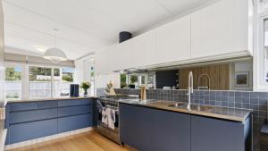 een grote keuken met blauwe kasten en blauwe tegels bij La Plage Portsea in Portsea