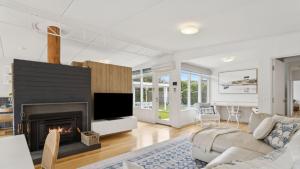 een woonkamer met open haard en een bank bij La Plage Portsea in Portsea