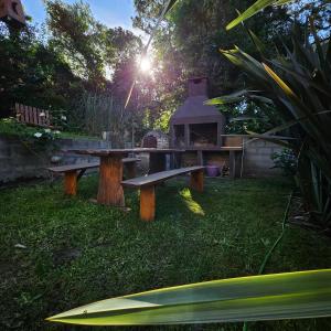 een picknicktafel in een tuin met een grill bij Gorriones Libres in Villa Gesell