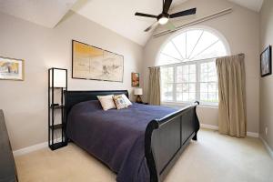 Majestic Home in Summer Oaks في أبيكس: غرفة نوم بها سرير ومروحة سقف