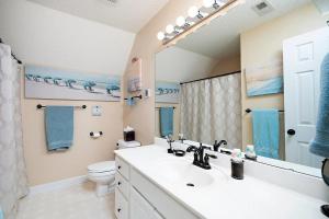 Un baño con lavabo, inodoro y espejo. en Majestic Home in Summer Oaks, en Apex 20 fotos más