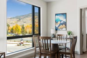 a dining room with a table and chairs and a large window at Skywalk Flats Mountainview Condo: Downtown, Rooftop Hot Tubs in Silverthorne