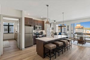 a kitchen with a large island with bar stools at Skywalk Flats Mountainview Condo: Downtown, Rooftop Hot Tubs in Silverthorne +41 photos