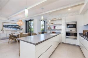 une cuisine avec des placards blancs et une salle à manger dans l'établissement 3 bd Condo with Ocean View Private Pool Cook, à Tapachula