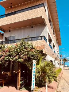 a building with a sign in front of it at Pousada Praia Dos Encantos in Japaratinga +13 photos