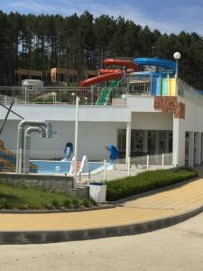 a pool on a cruise ship with a water slide at First Line Apartment at Obzor in Obzor