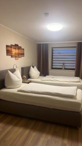 two large beds in a room with a window at Ferienwohnung Sandra in Heilbad Heiligenstadt