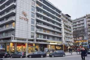 a large building with cars parked in front of it at Black and white suites 2 in Thessaloniki