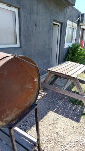 un barbecue rouillé et une table de pique-nique devant un bâtiment dans l'établissement Lo de Andrés y Marina, à Arroyo de Los Patos 6 autres photos