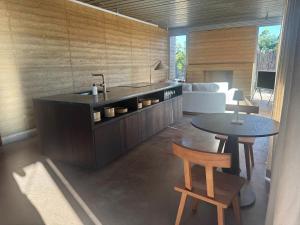 a kitchen with a sink and a table and a couch at Cardinal Cabin at Gamenthaler in Fredericksburg
