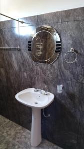 une salle de bain avec un lavabo et un miroir au mur dans l'établissement Lo de Andrés y Marina, à Arroyo de Los Patos