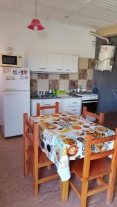 une cuisine avec une table avec des chaises et un réfrigérateur dans l'établissement Lo de Andrés y Marina, à Arroyo de Los Patos