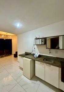 a kitchen with white cabinets and a counter top at 957 golden fortaleza frente mar in Fortaleza