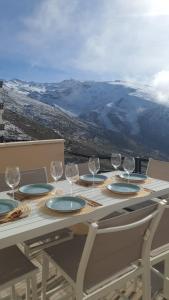 a table with wine glasses and plates on it at SnowGranada Los Valles Daniela House in Monachil